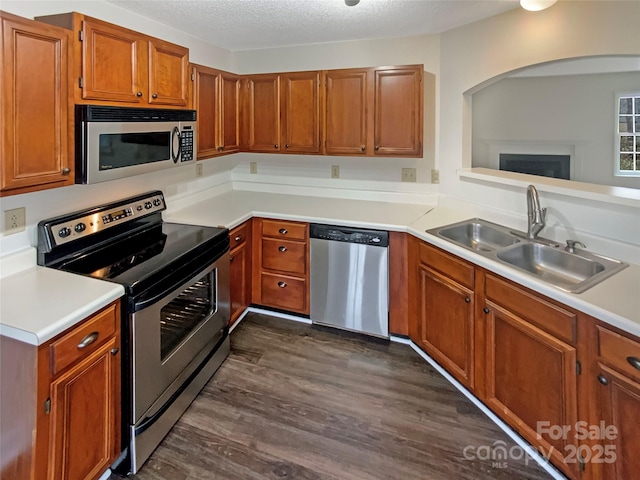 kitchen featuring stainless steel appliances, dark hardwood / wood-style flooring, sink, and a textured ceiling