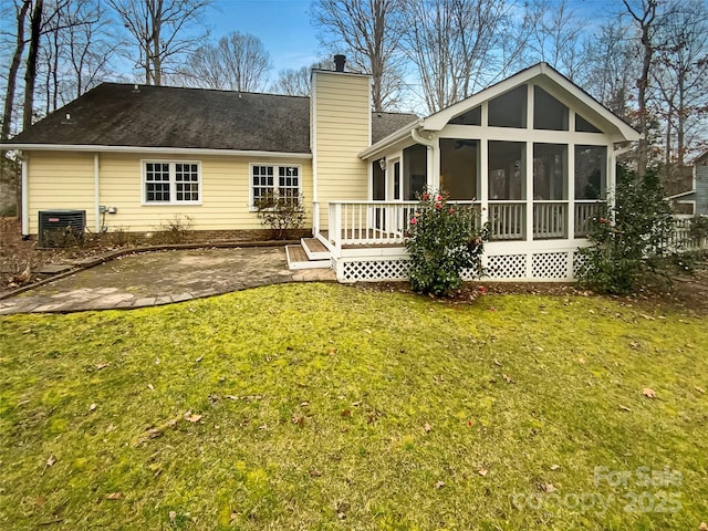 rear view of property featuring central AC, a patio area, a lawn, a deck, and a sunroom