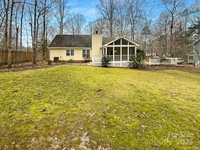 back of house featuring a yard and a sunroom