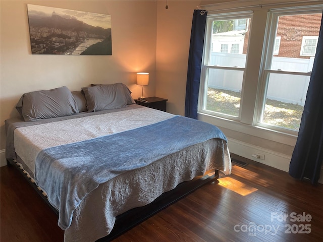 bedroom with dark hardwood / wood-style flooring