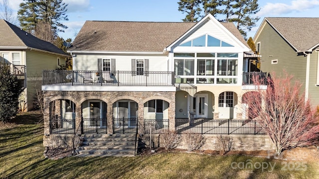 back of property with a balcony and a lawn