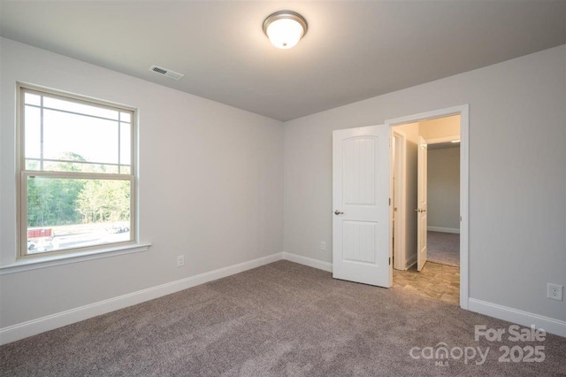 spare room featuring light colored carpet