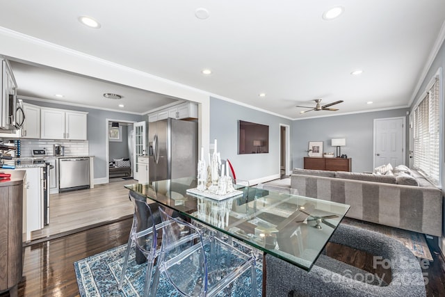 dining room with hardwood / wood-style flooring, ornamental molding, and ceiling fan