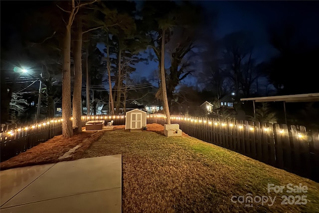 yard at night featuring a storage shed