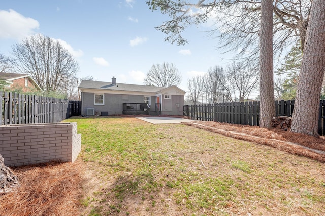 rear view of house featuring a yard, central AC, and a patio area