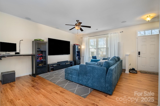 living area with ceiling fan, baseboards, and wood finished floors