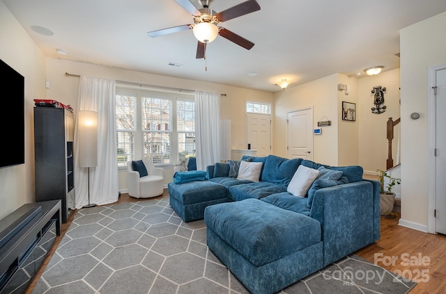 living area with visible vents, a ceiling fan, wood finished floors, and baseboards