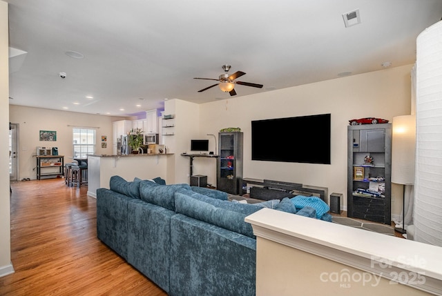 living room with light wood-style flooring, recessed lighting, visible vents, and ceiling fan