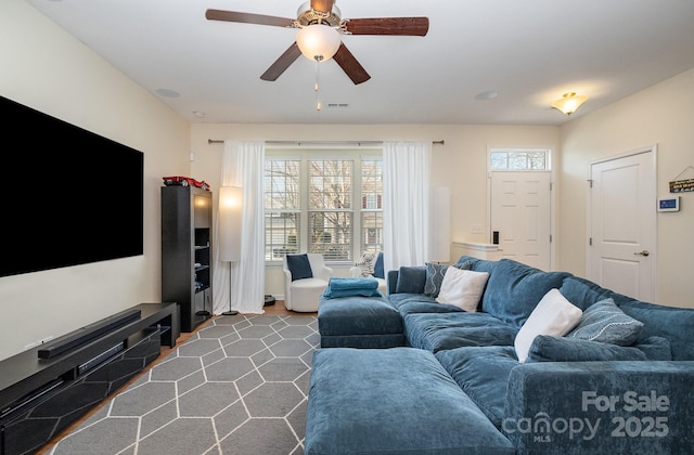 carpeted living room featuring ceiling fan and visible vents