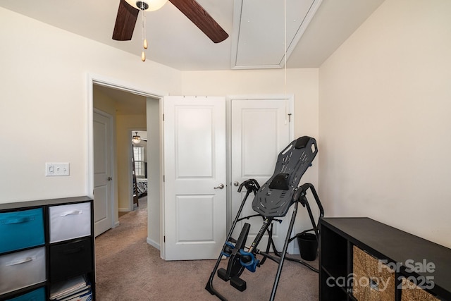 workout room with light colored carpet, attic access, and a ceiling fan