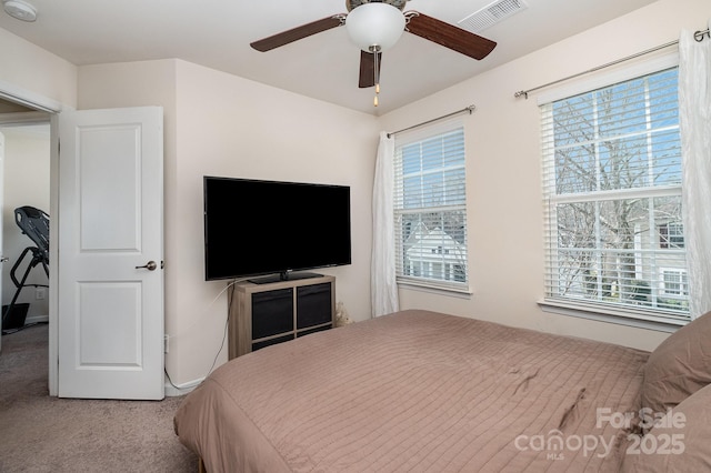 bedroom featuring ceiling fan, light colored carpet, and visible vents