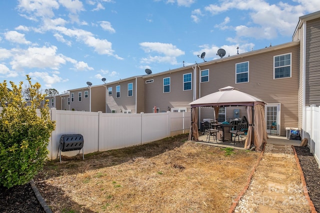 rear view of house featuring a patio, a gazebo, and a fenced backyard