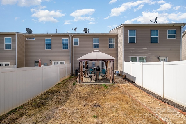 back of house featuring a fenced backyard, a gazebo, and a patio