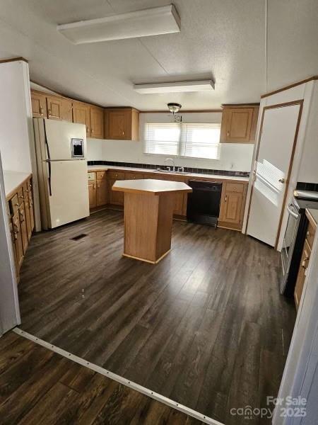 kitchen with a center island, dark hardwood / wood-style floors, dishwasher, white fridge, and stainless steel electric stove