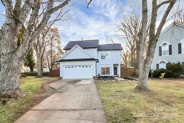 traditional-style home with an attached garage, concrete driveway, and a front yard