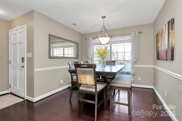 dining space featuring dark wood-style floors, baseboards, and visible vents