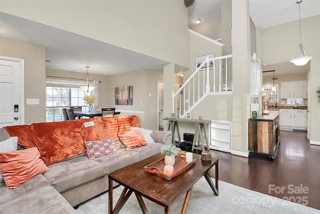 living room featuring stairs, a high ceiling, and dark wood finished floors