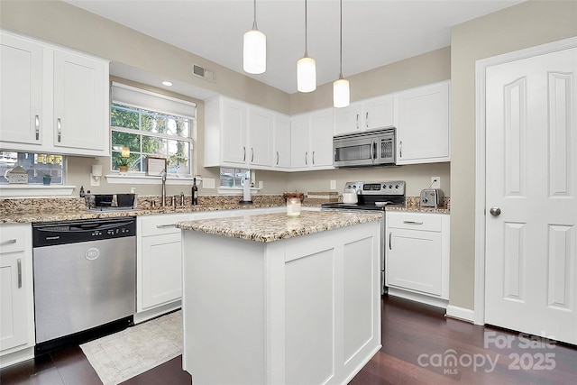 kitchen with appliances with stainless steel finishes, a center island, and white cabinetry