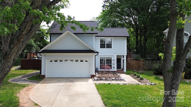 traditional-style home featuring fence, driveway, and a front yard