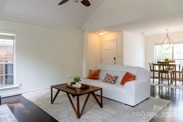living area featuring lofted ceiling, a ceiling fan, wood finished floors, and crown molding