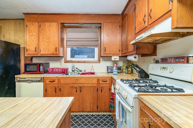 kitchen with black refrigerator, dishwasher, sink, white range with gas stovetop, and a textured ceiling