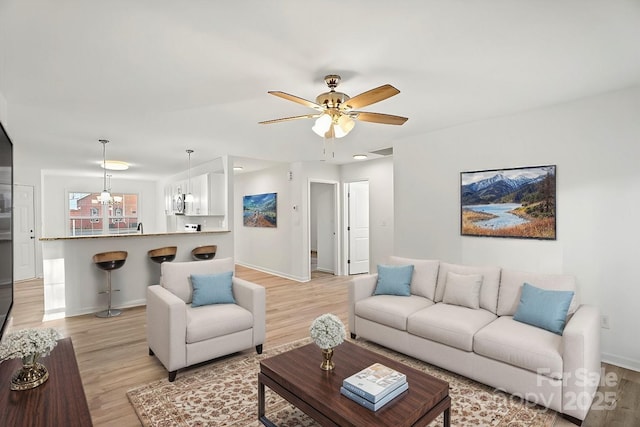 living room featuring ceiling fan and light hardwood / wood-style floors