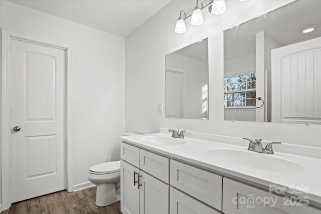 bathroom with hardwood / wood-style flooring, vanity, and toilet