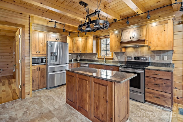 kitchen featuring appliances with stainless steel finishes, wood walls, a kitchen island, and wood ceiling