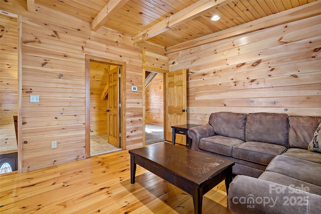 living area with wooden ceiling, wood walls, light wood finished floors, and beamed ceiling