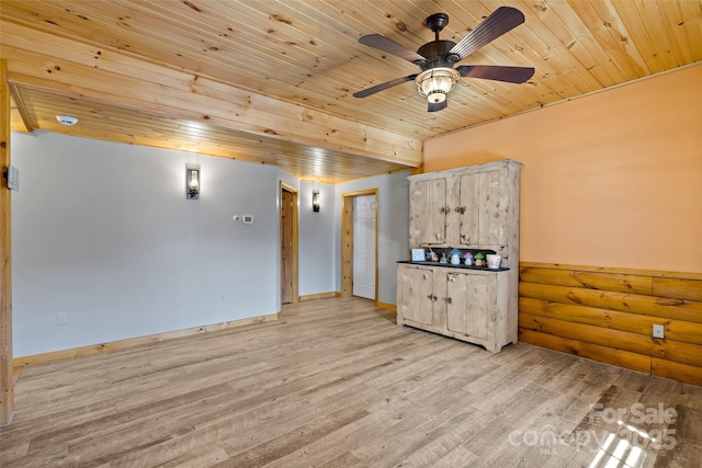 empty room featuring light wood finished floors, wood ceiling, baseboards, and ceiling fan