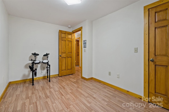 spare room with light wood-style flooring and baseboards