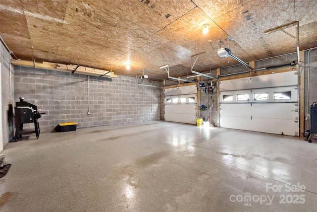 parking garage featuring concrete block wall and a garage door opener