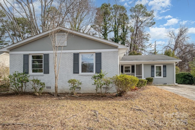 view of front of home with crawl space and brick siding