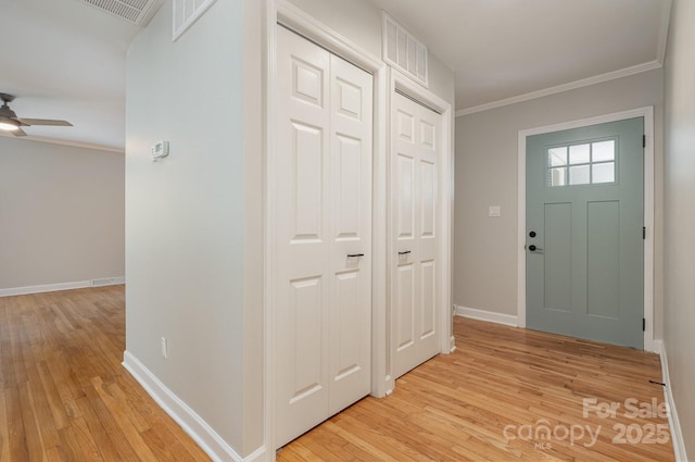 foyer featuring crown molding, ceiling fan, baseboards, and light wood-style floors