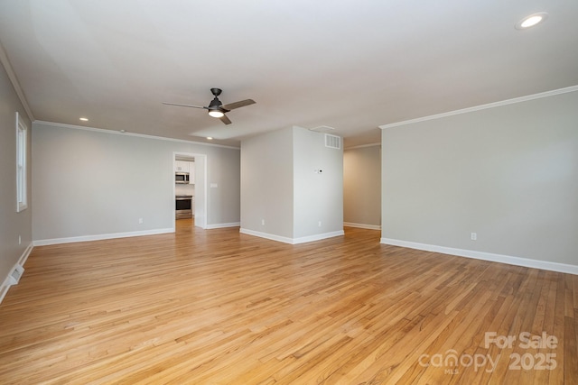 empty room featuring a ceiling fan, light wood-type flooring, crown molding, and baseboards