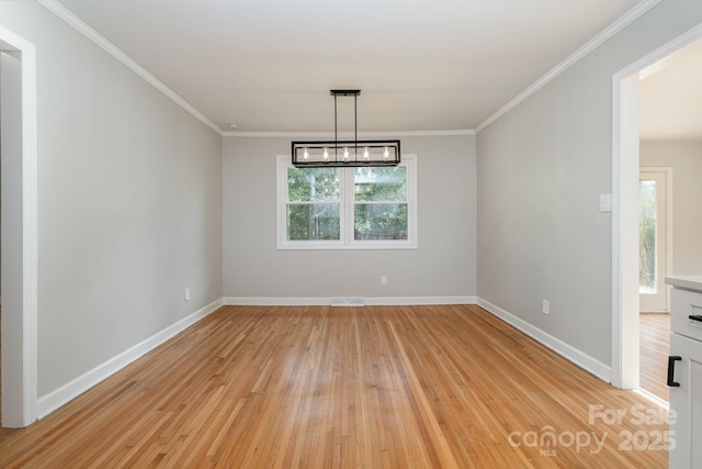 unfurnished dining area featuring ornamental molding and light wood-type flooring