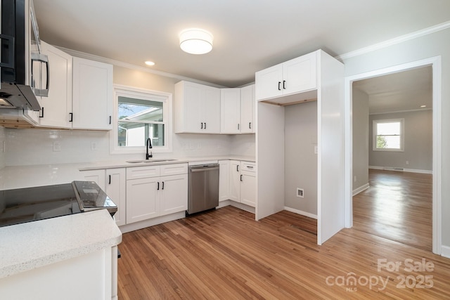 kitchen featuring ornamental molding, stainless steel appliances, sink, and white cabinets