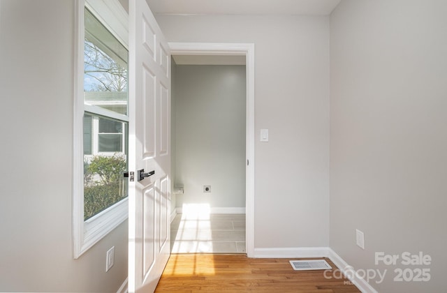 interior space with light wood-type flooring, visible vents, and baseboards