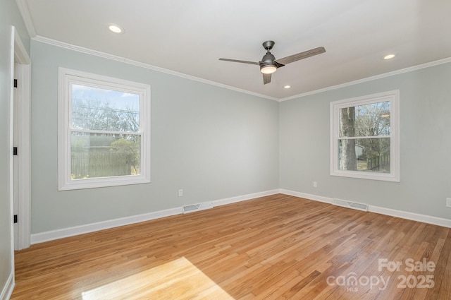 spare room with light wood-style flooring, visible vents, and a healthy amount of sunlight