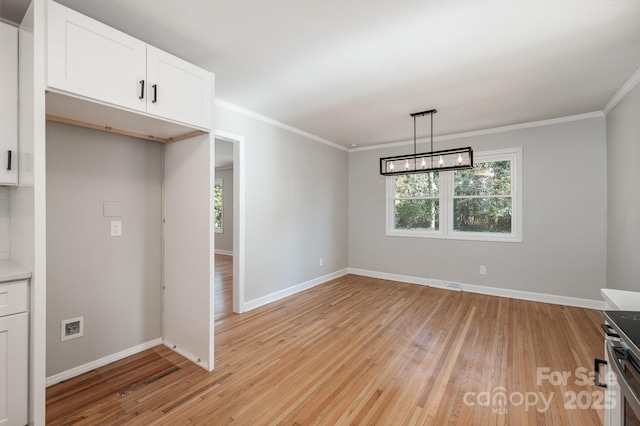 unfurnished dining area with crown molding, a notable chandelier, and light hardwood / wood-style floors