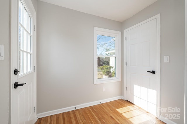 doorway to outside featuring light wood finished floors and baseboards