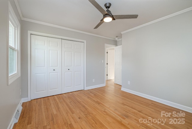 unfurnished bedroom with visible vents, ornamental molding, light wood-style flooring, and baseboards