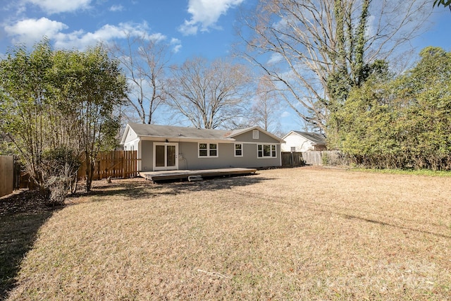 back of house with a deck, a yard, a fenced backyard, and stucco siding