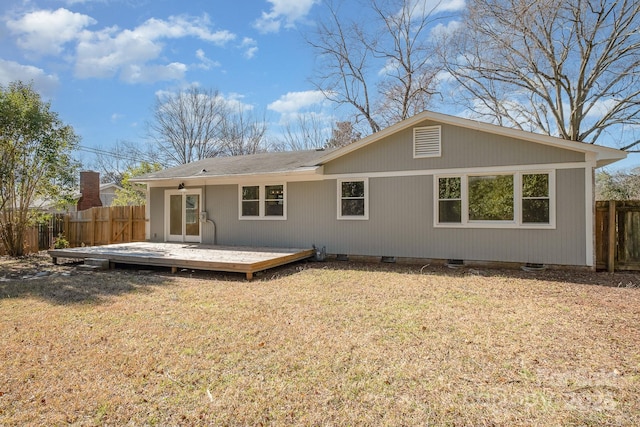 back of property featuring crawl space, fence, a deck, and a lawn