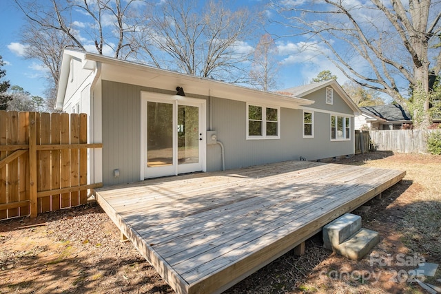 rear view of property with fence and a wooden deck