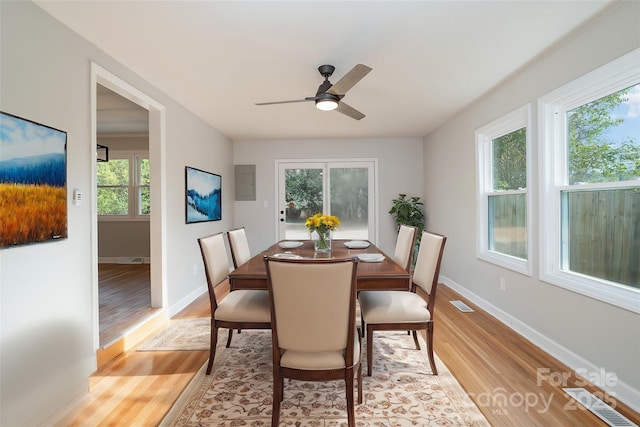 dining area with light wood-style floors, visible vents, and baseboards