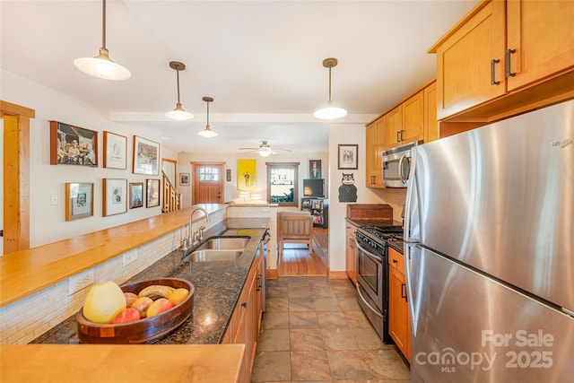 14 Drake St, Asheville, NC 28806 - kitchen with appliances with stainless steel finishes, a sink, dark stone finish flooring, ceiling fan, and hanging light fixtures