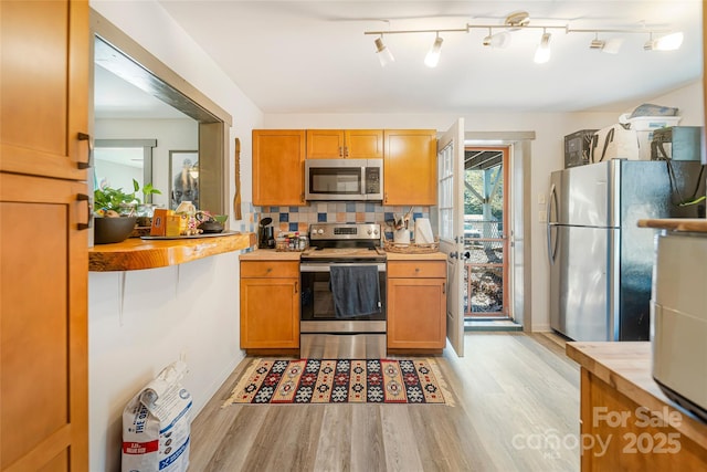 14 Drake St, Asheville, NC 28806 - kitchen featuring appliances with stainless steel finishes, light wood finished floors, light countertops, backsplash, and brown cabinets