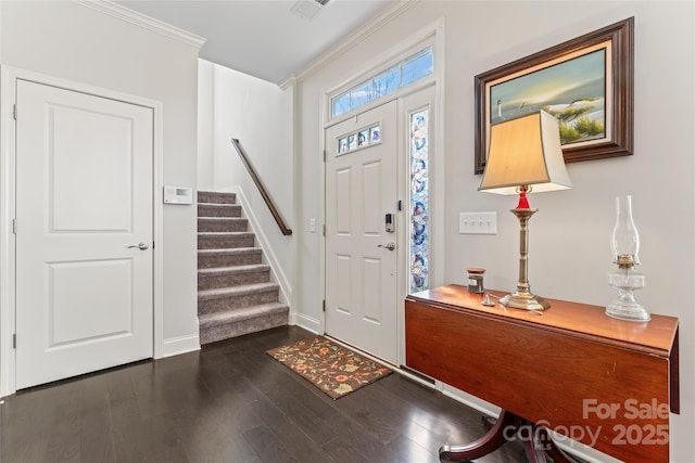 foyer entrance featuring ornamental molding and dark hardwood / wood-style floors