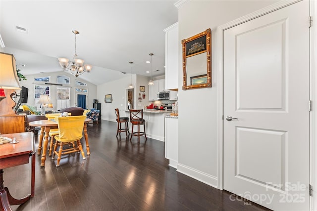 dining area with vaulted ceiling, an inviting chandelier, and dark hardwood / wood-style flooring